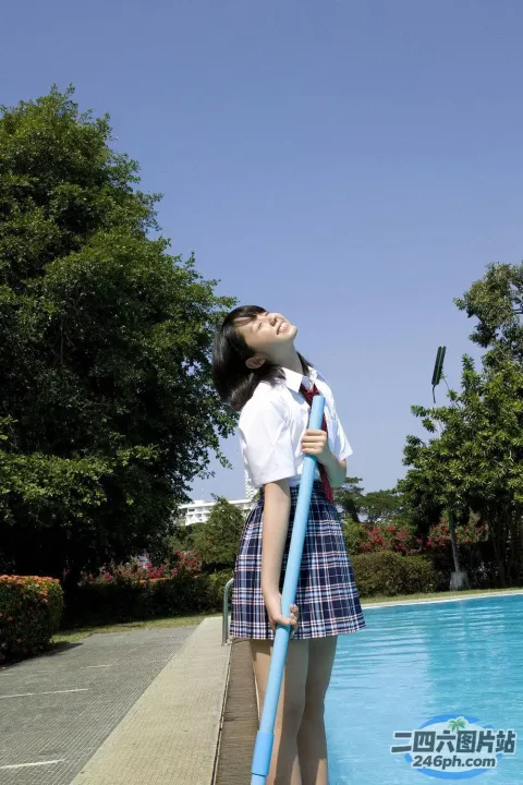 穿着校服的 arafed 女孩站在游泳池旁边