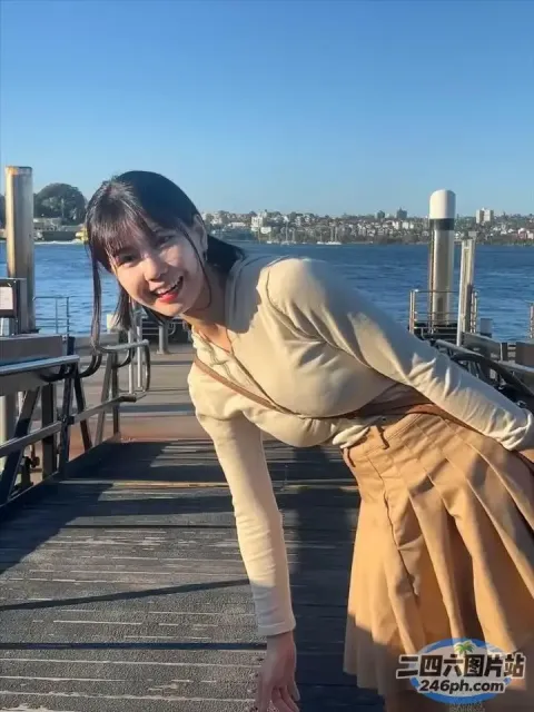 码头上站着一个女人，手里拿着滑板