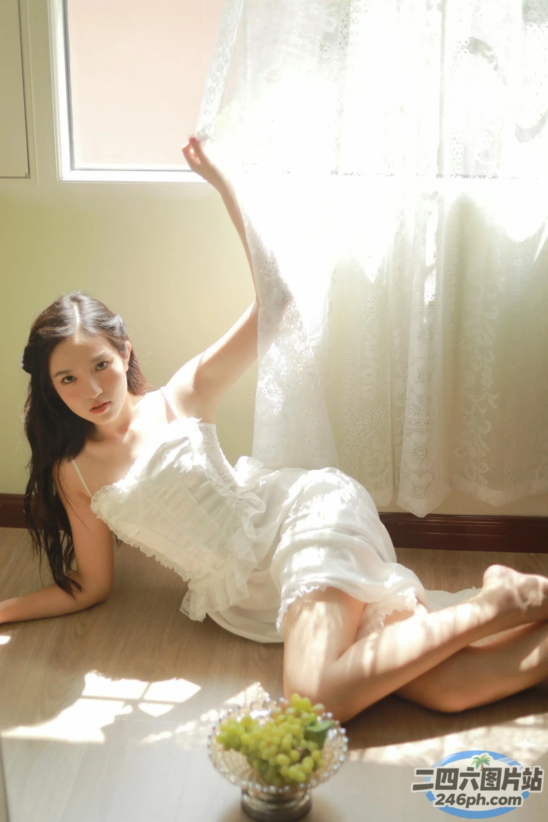 穿着白色连衣裙的阿拉夫德女人躺在窗边的地板上