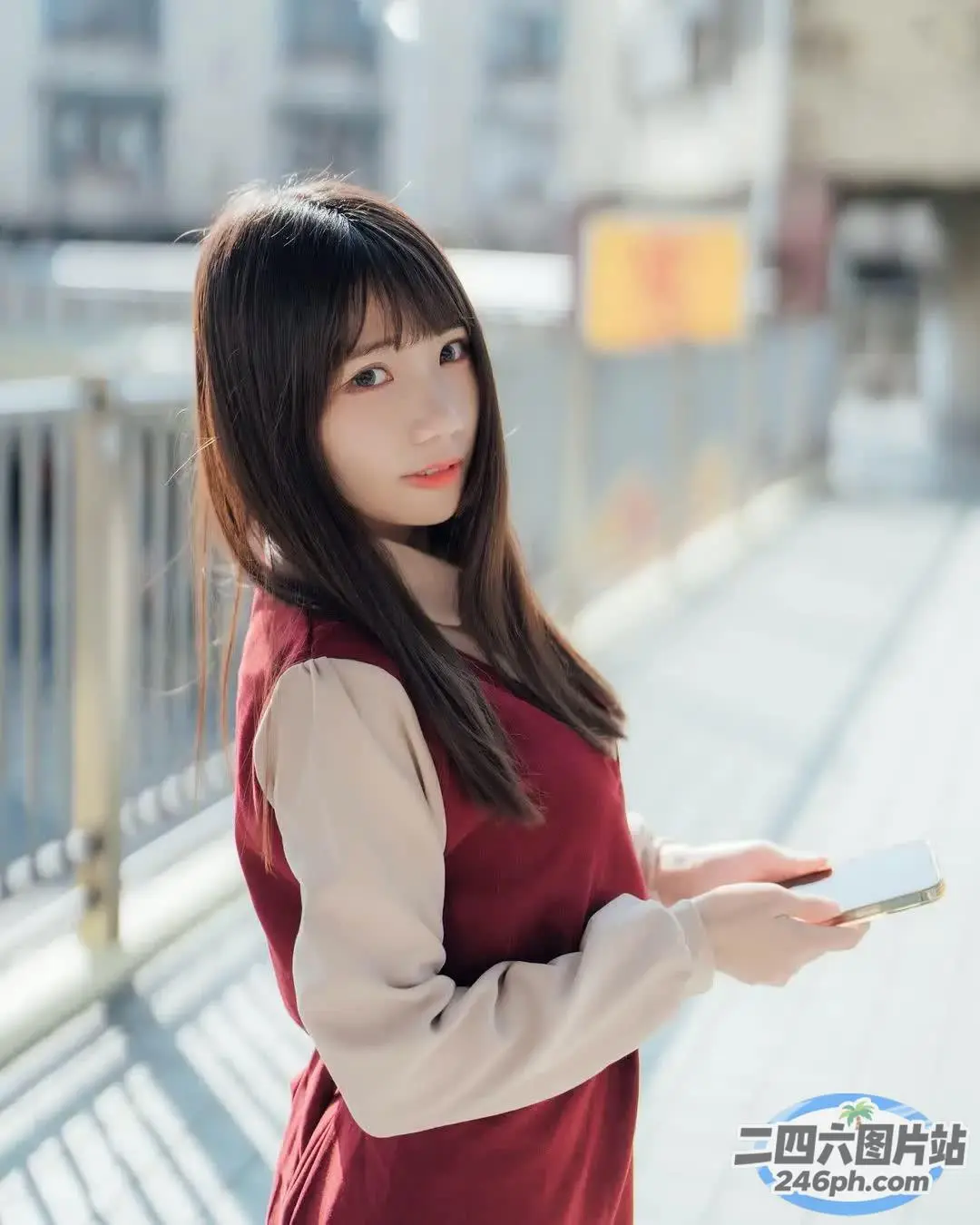 人行道上站着一个女人，手里拿着手机