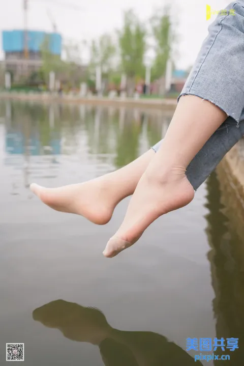 一个人坐在水体上方的壁架上