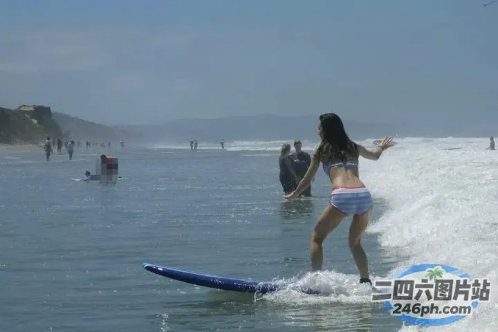 冲浪者在阳光明媚的日子里在海滩上乘风破浪