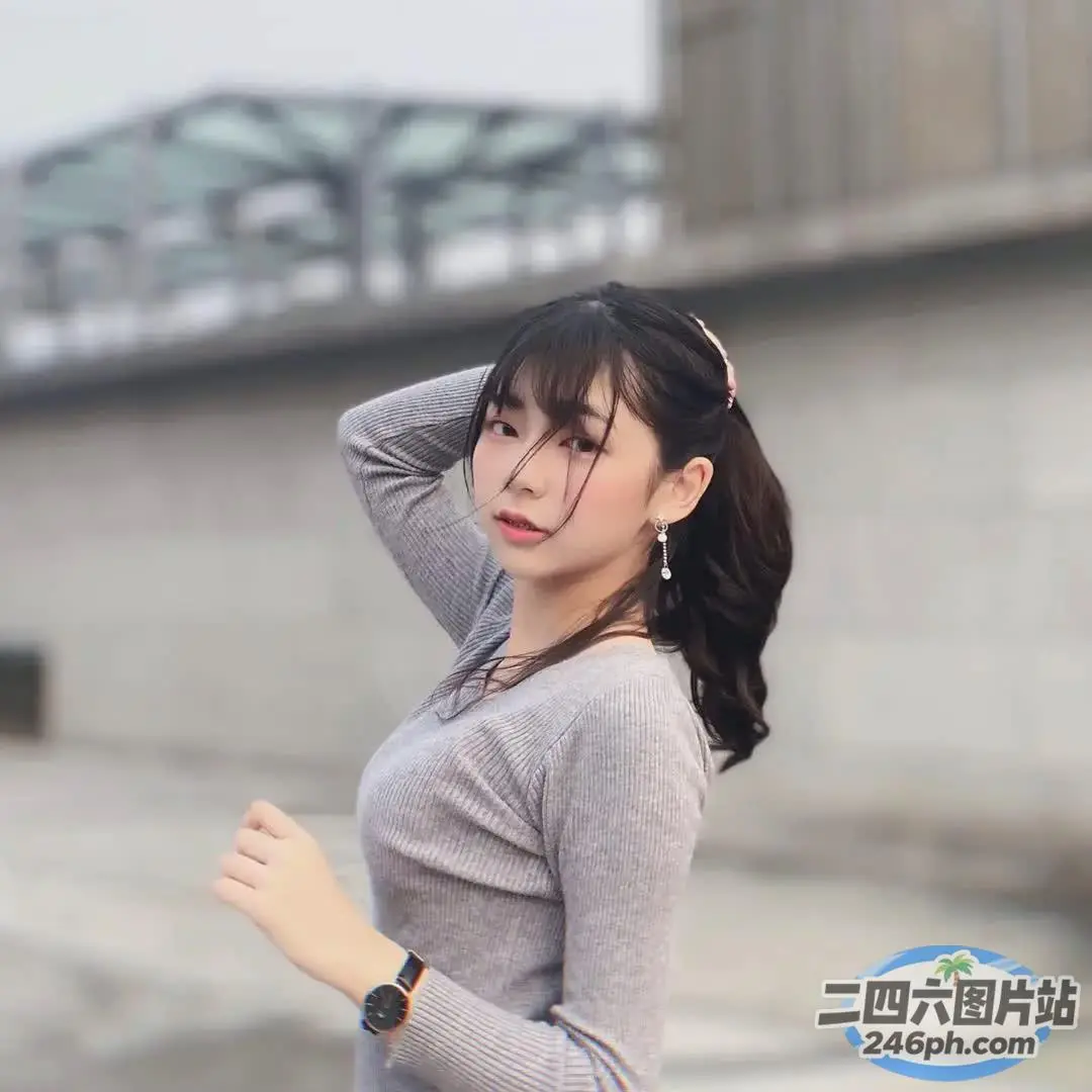 一个穿着灰色衬衫和黑色裤子的女人的特写