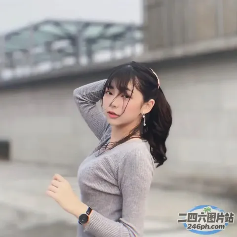 一个穿着灰色衬衫和黑色裤子的女人的特写