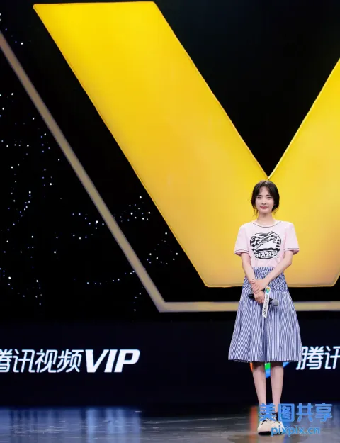 舞台上站着一个女人，拿着麦克风