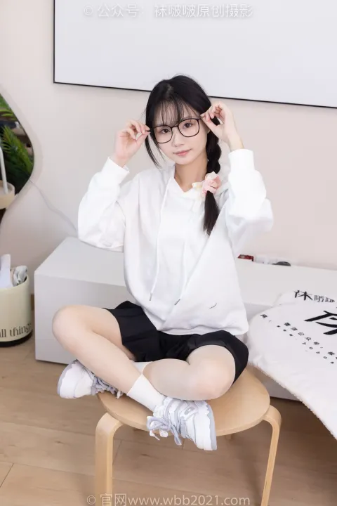 一名女士坐在凳子上，头上戴着一副眼镜