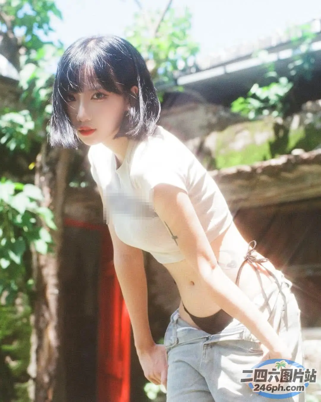 身穿白衬衫和牛仔裤的亚洲女性靠在墙上
