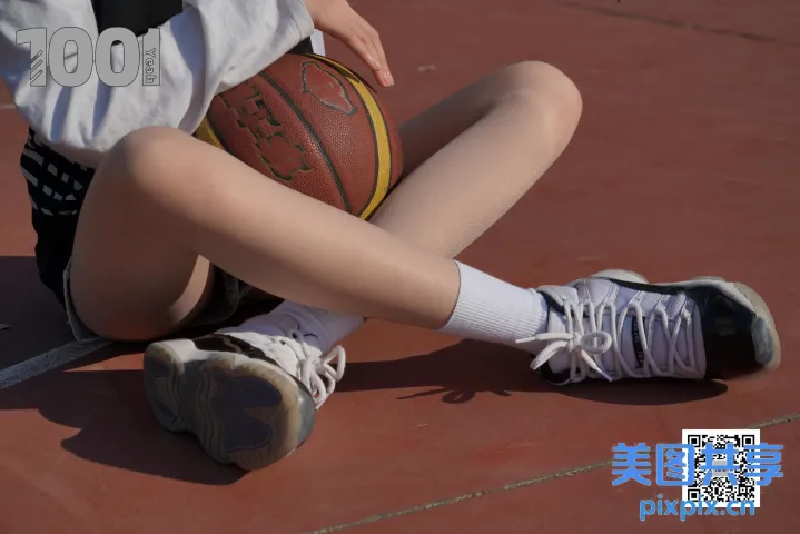 阿拉菲德女孩拿着篮球坐在地上