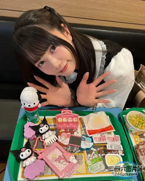 阿拉夫德亚洲女孩坐在桌子旁，手里拿着一盘食物