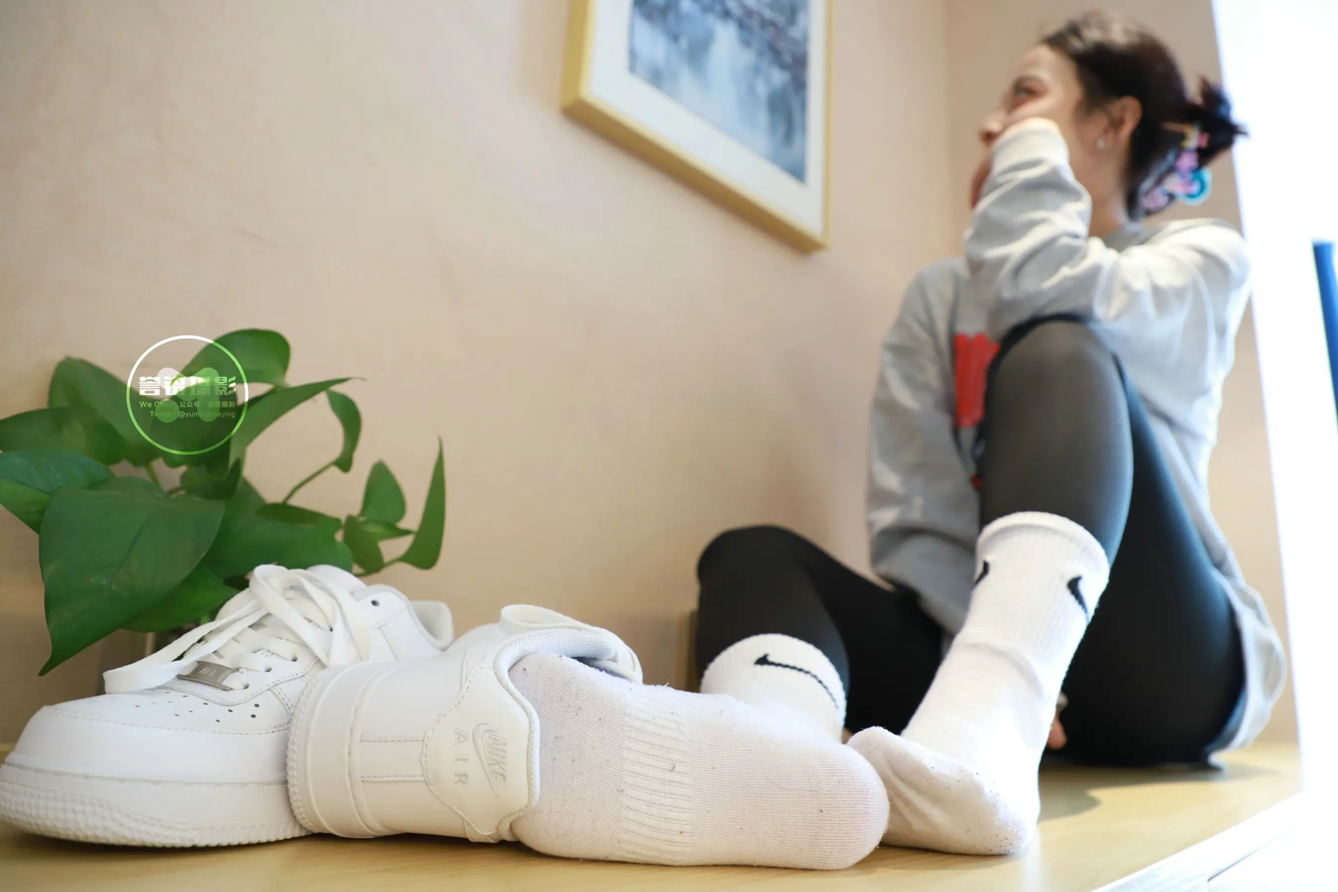 有一个女人坐在桌子上，双脚抬起