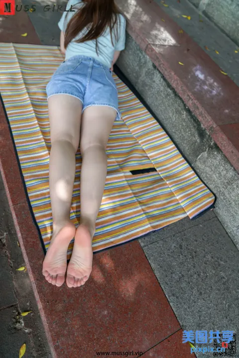 被拉夫的妇女躺在人行道上的毛巾上，双脚抬起