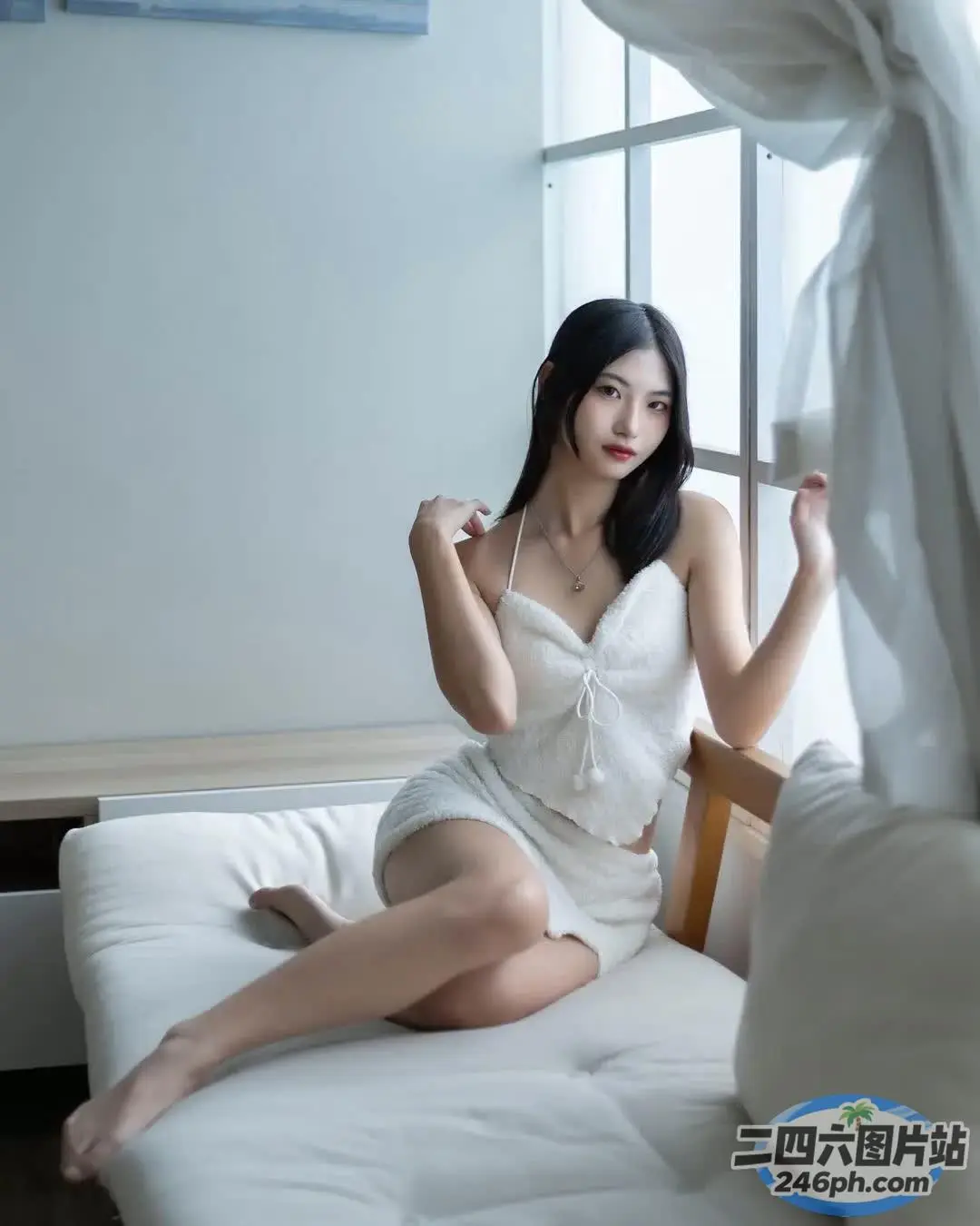 坐在床上的白裙亚洲女子