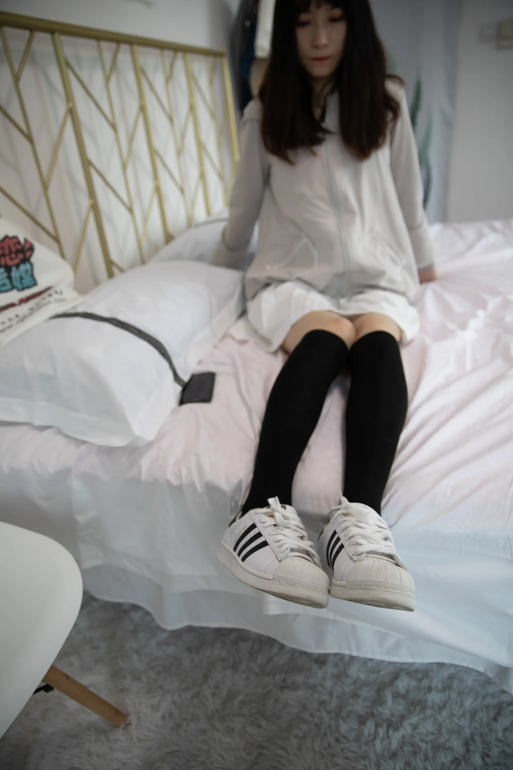 有一个女人坐在床上，双腿交叉
