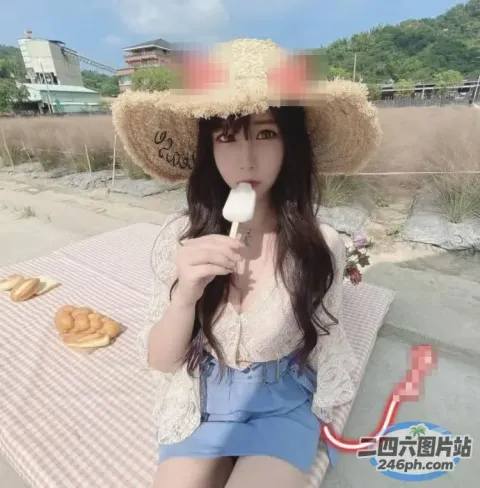 戴草帽的 araffe 女孩在海滩上吃冰棒