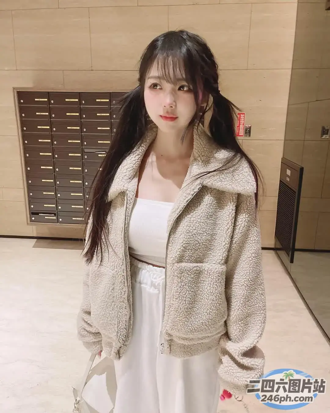 一个穿着白色连衣裙和夹克的女人站在房间里