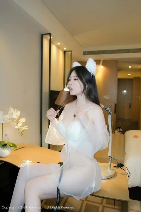 穿着白色内衣的 Araffe 坐在酒店房间的桌子上