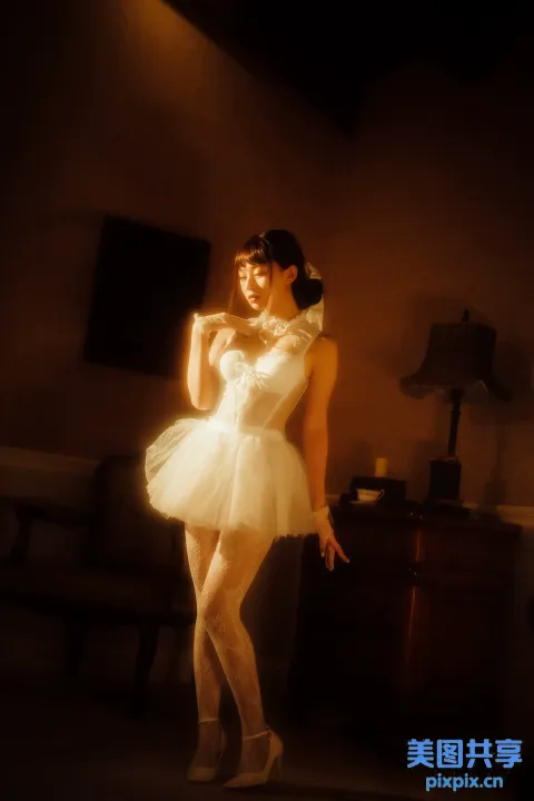 有个身穿白色连衣裙的女子摆姿势拍照