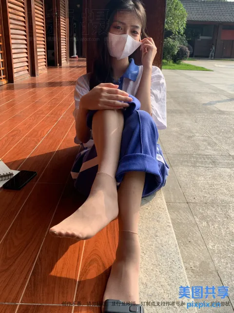 地板上坐着一个戴着口罩的女人