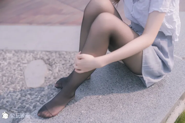 有个女人坐在长凳上，双腿交叉