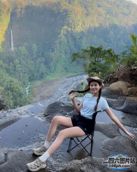 阿拉夫德女人坐在一块石头上，手里拿着一杯饮料