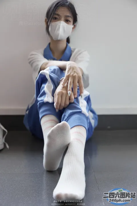 坐在地板上戴着医用口罩的 Arafed 女人