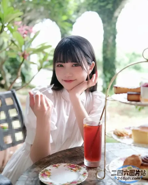 有个女人坐在一张桌子旁，桌上放着一盘食物