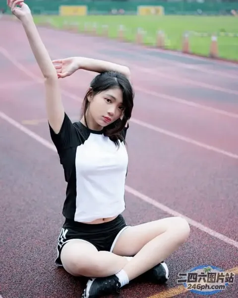 一名女子高举双臂坐在跑道上