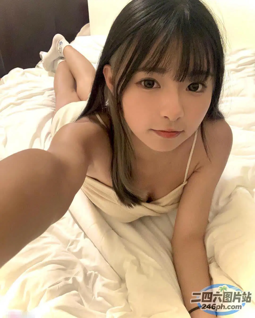 arafed 亚洲妇女躺在床上，上面铺着白色床单