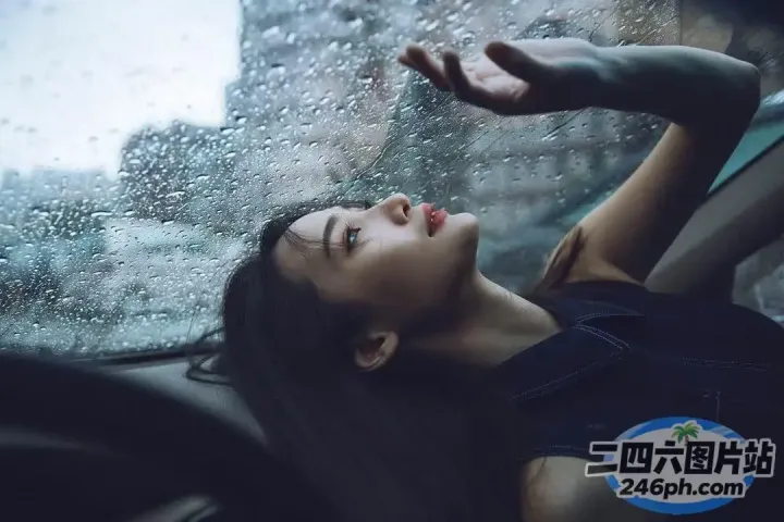 阿拉菲德女人坐在车里，在雨中望向窗外