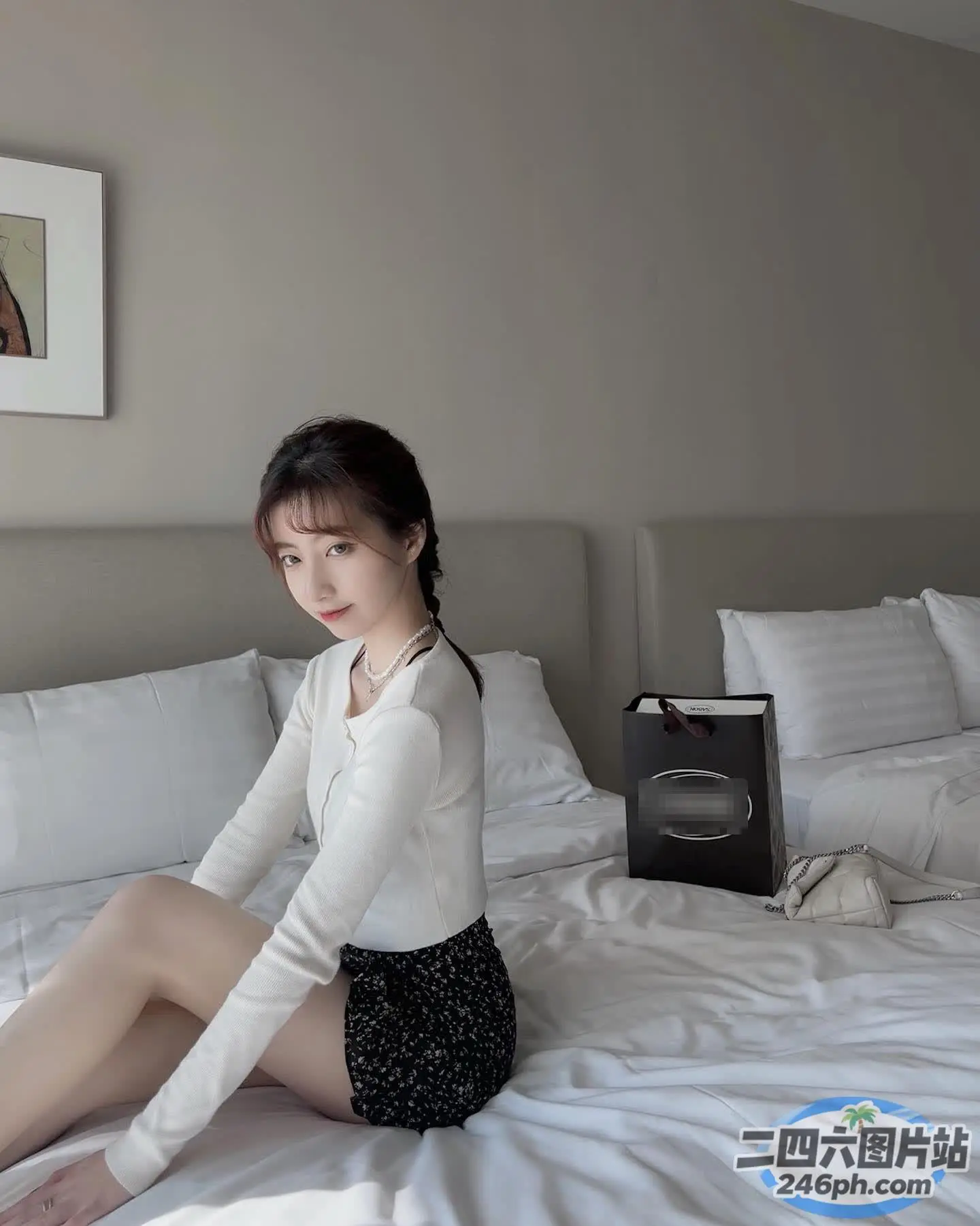 床上坐着一个穿着白衬衫的女人