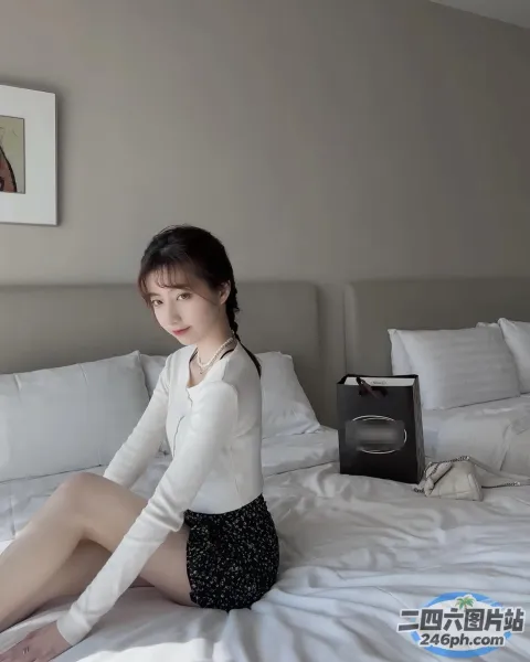 床上坐着一个穿着白衬衫的女人