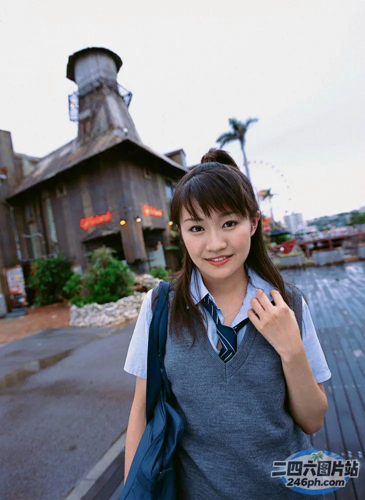有个女人站在有钟楼的楼前