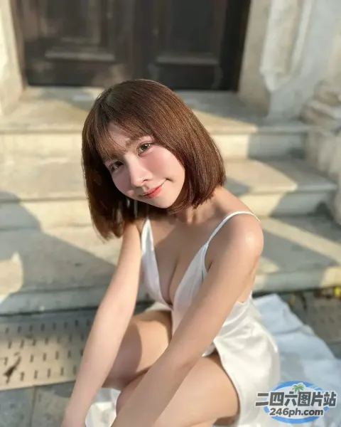 一个穿着白色连衣裙坐在台阶上的女人的特写