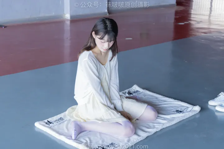 坐在健身房垫子上的 arafed 女人