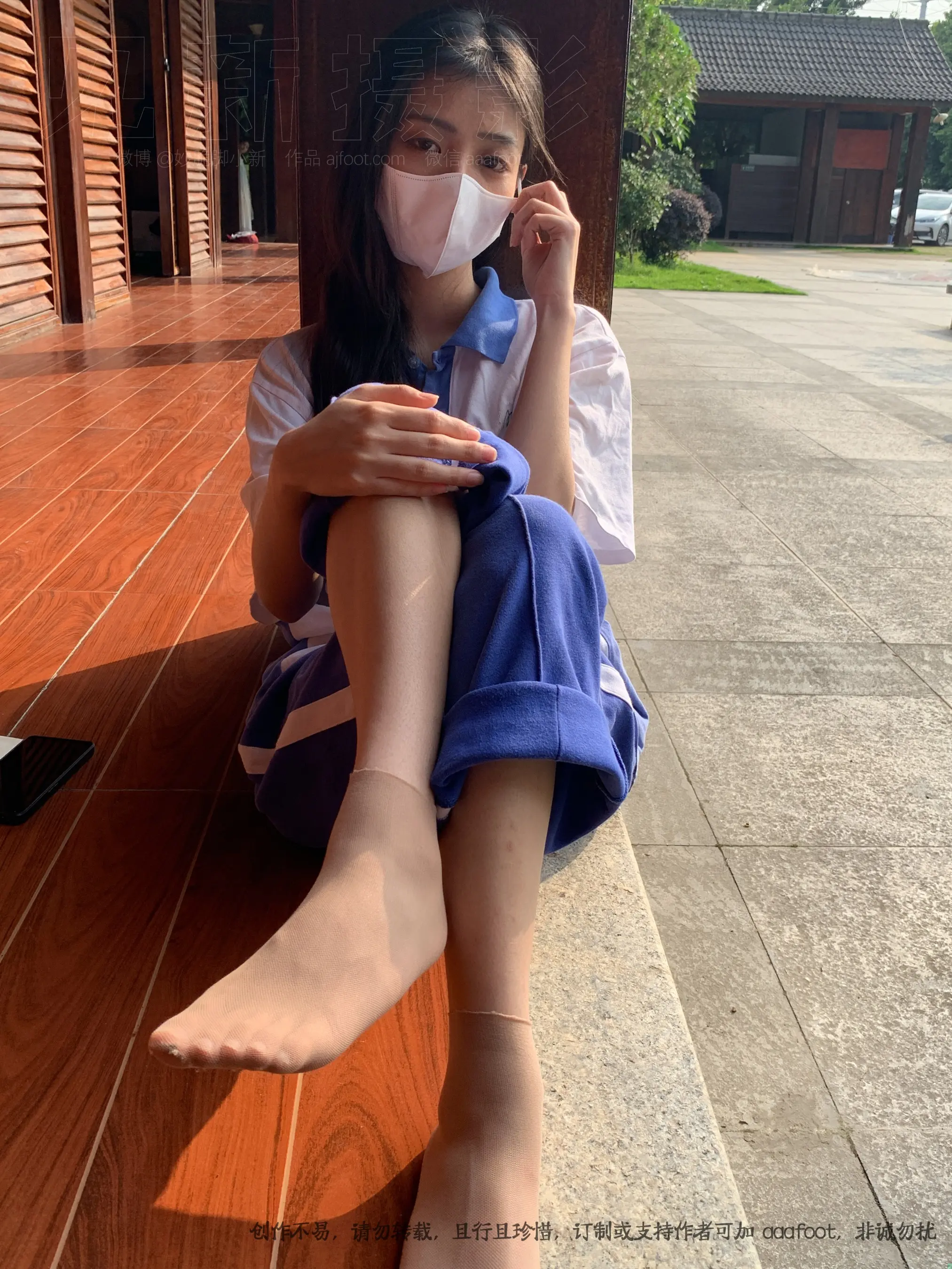 戴着口罩坐在地板上的 arafed 亚洲女孩