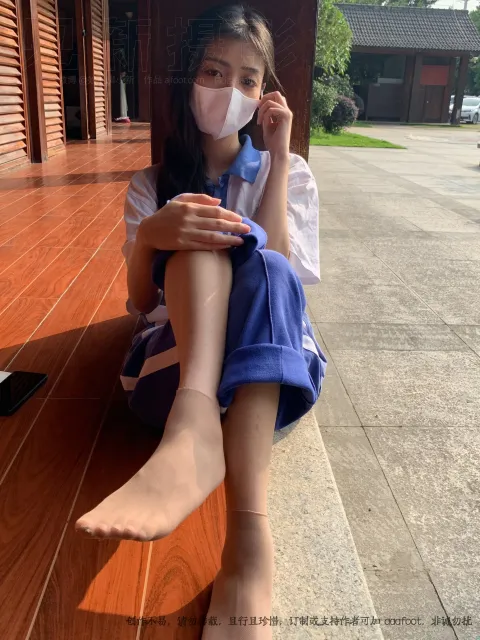 戴着口罩坐在地板上的 arafed 亚洲女孩