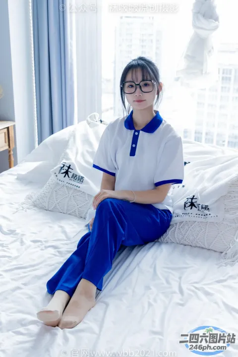 穿着白色和蓝色服装坐在床上的 arafed 女人