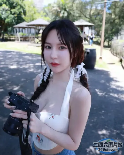 一名女子在公园里拿着相机的特写