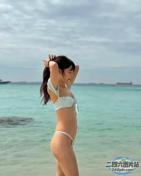 穿着白色比基尼的 arafed 女人站在海滩上