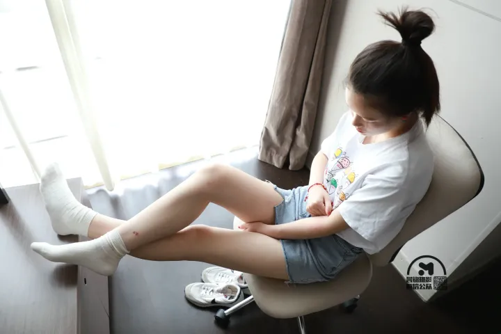 有个女人坐在椅子上，双腿交叉