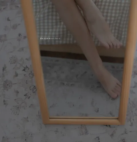 床上的镜子里有一个女人的腿