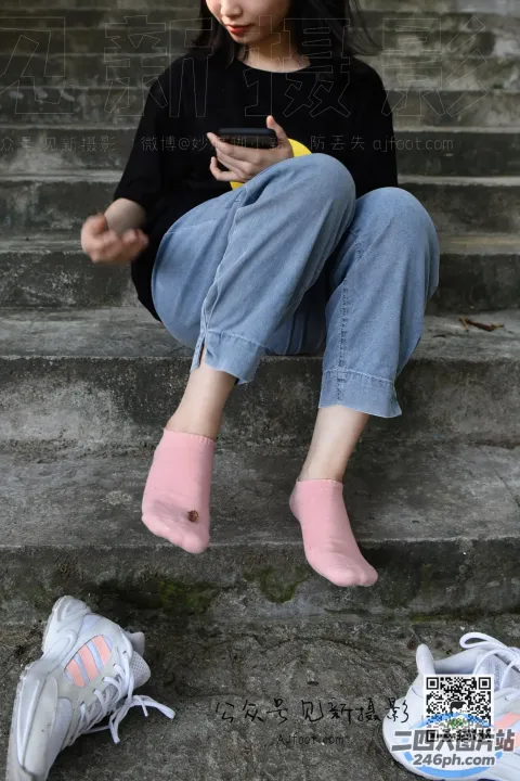 坐在台阶上用手机的 Araffe 女孩