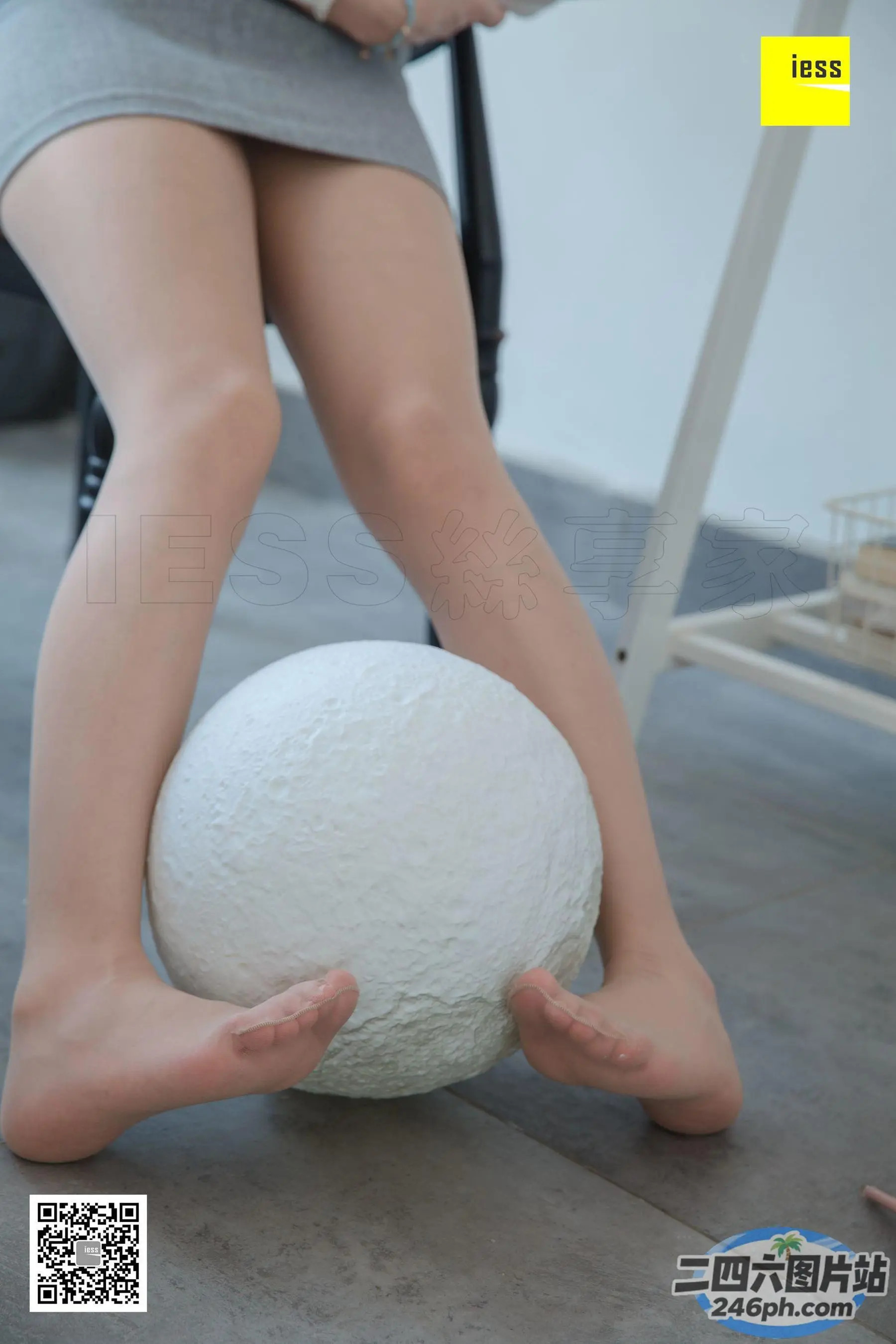 有个女人坐在椅子上，手里拿着一个球