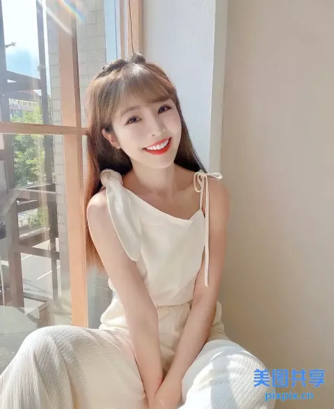 一个穿着白色连衣裙坐在床上的女人