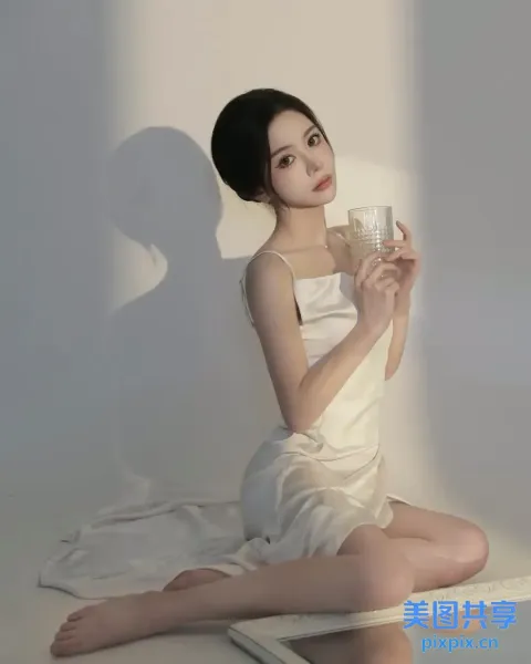 阿拉菲女子坐在地板上，手里拿着一杯水