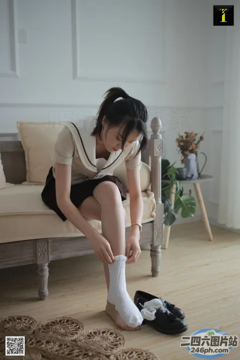 有一个女人坐在沙发上，脚踩着一双鞋