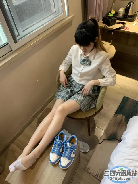 一个女人坐在椅子上，双脚抬起，穿着一双蓝色的鞋子