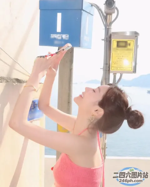 粉色上衣女子用手机拍水照片