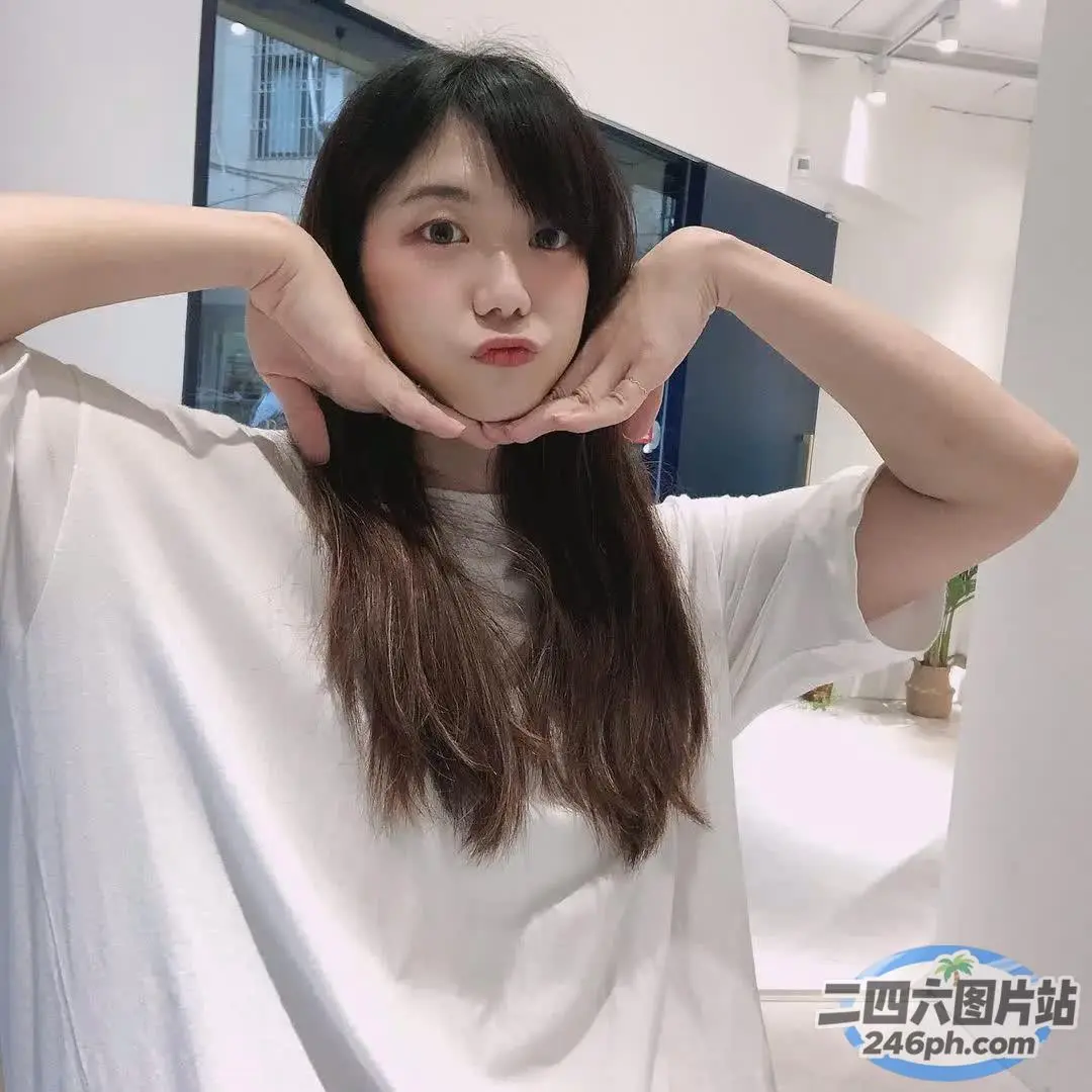 一位长发女子正在用手做心形手势