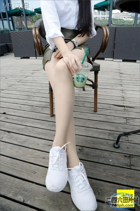 有个女人坐在长凳上，手里拿着一杯饮料
